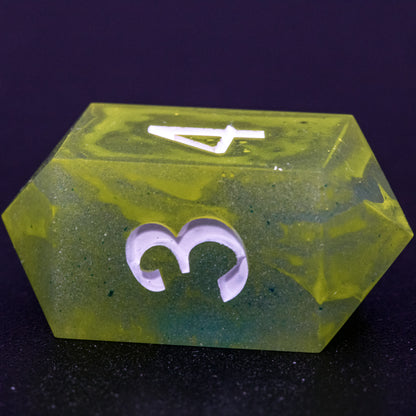 Close up of D4 Bog Brew die, featuring white numbers, yellow-green swirls on blue-green base resin.