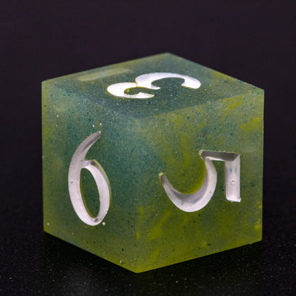 Close up of D6 Bog Brew die, featuring white numbers, yellow-green swirls on blue-green base resin.