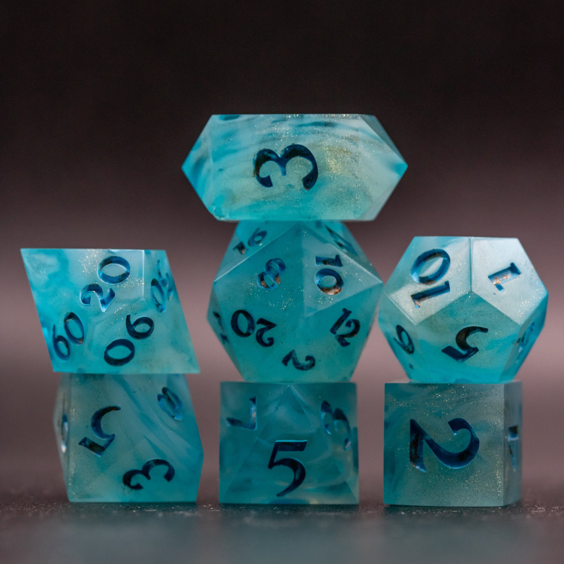 Top lit full set of Golden Sands dice with blue-white swirls with speckled gold, to showcase translucency.