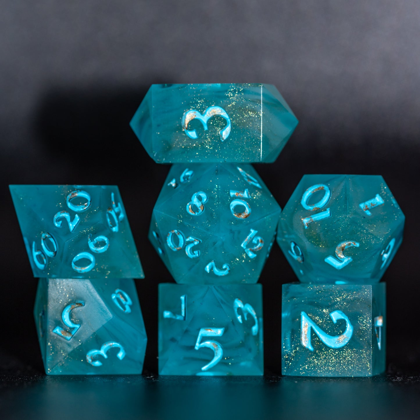 Front lit full set of Golden Sands dice with blue-white swirls with speckled gold, to showcase painted blue numbers with dabbed gold.