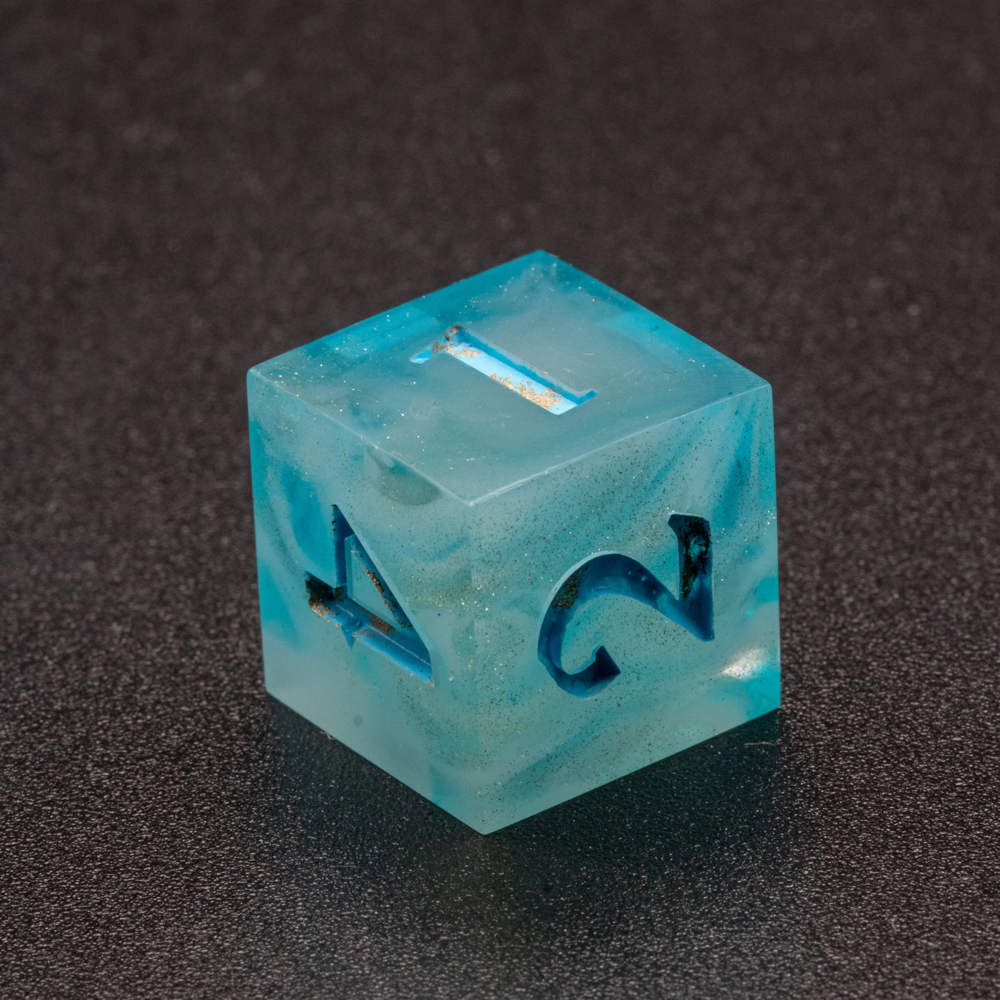 Zoomed in photo of a wavy blue-white and speckled gold D6 die.