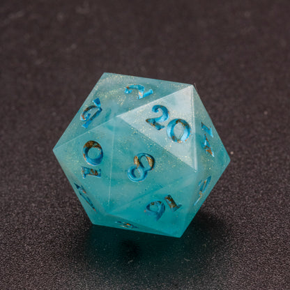 Zoomed in photo of a wavy blue-white and speckled gold D20 die.