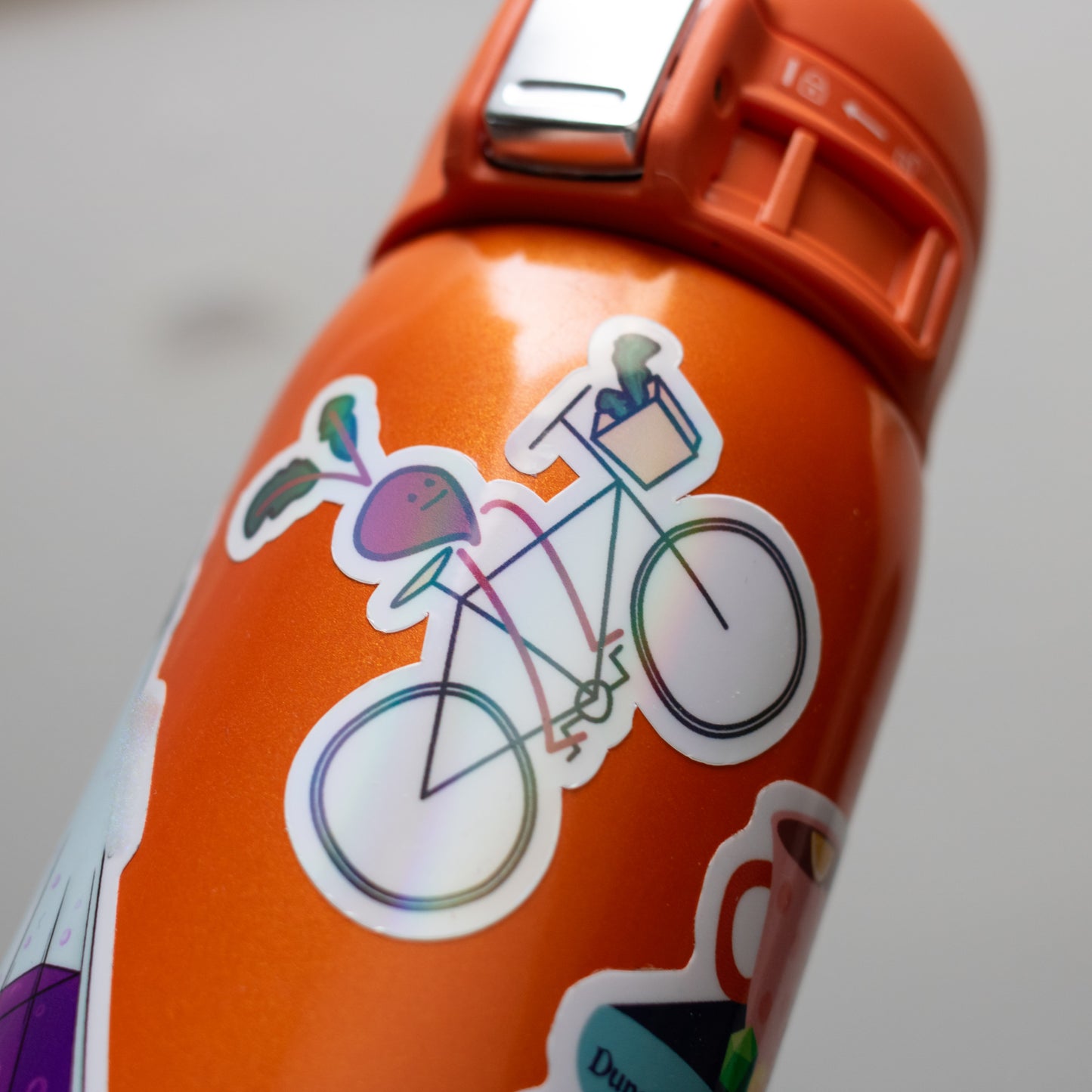 Photo of the holographic Beet Bike sticker on an orange water bottle.