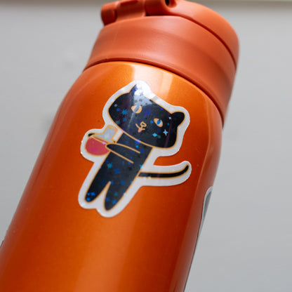 Potion Cat starry holographic sticker on an orange water bottle.