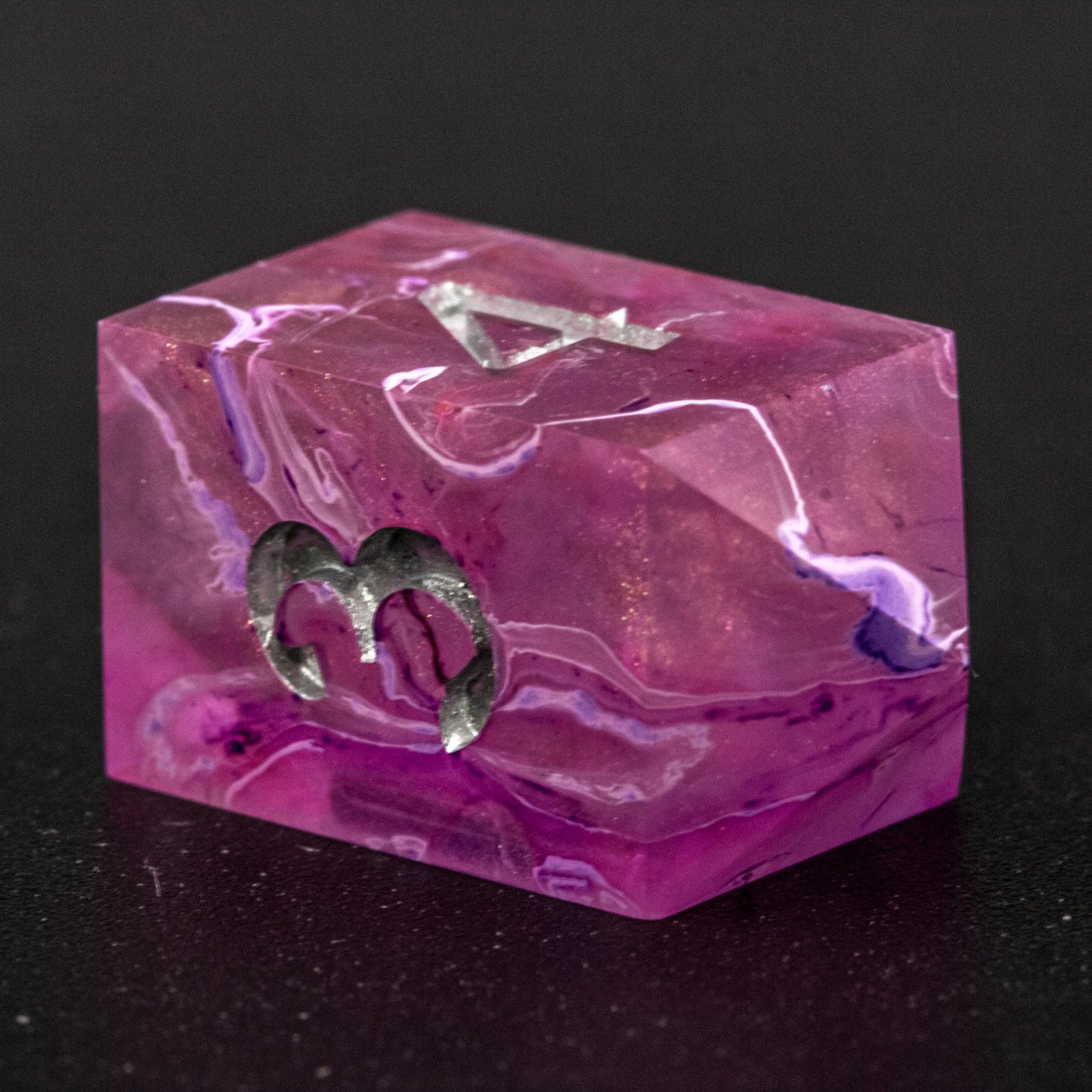 Close up of Soul Crystal D4 die, featuring purple and pink swirls over a pink translucent base with sparkly gold, and silver-painted numbers.